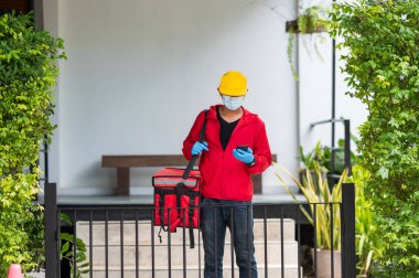 teslimatçı kırmızı bez. Cep telefonuyla müşteri adresi aranıyor.