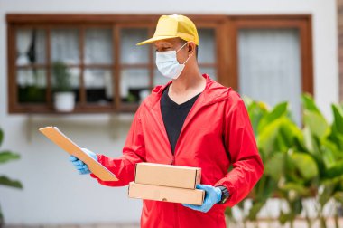 Teslimatçı, kırmızı eldiven giymiş, elinde karton kutu tutan, kırmızı eldiven giyen, elinde karton kutular tutan mavi eldivenli bir adam.
