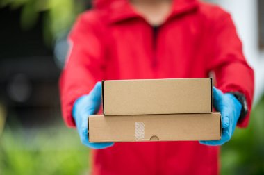 Teslimatçıyı kapat. Kırmızı eldivenli, elinde bir kutu var.
