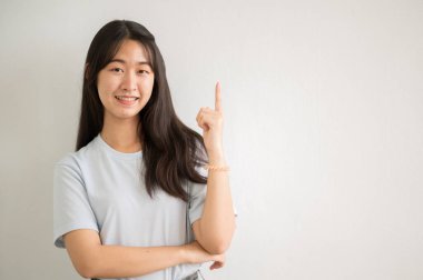 Asyalı bir kız üniversite öğrencisi üniversiteye gülümsedi ve kameraya baktı..