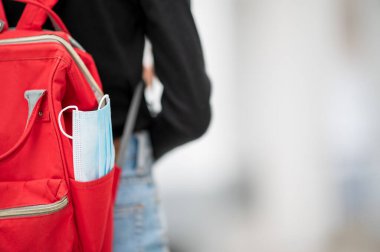 Öğrenciler üniversitedeki çalışmaları sırasında çantalarında bir maske hazırlarlar..