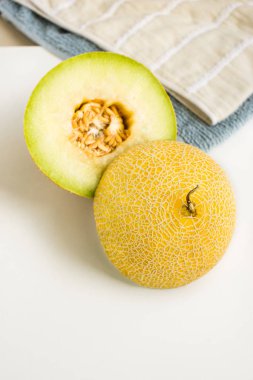 Mutfak masasının üzerinde havlu ile kavun iki halfs