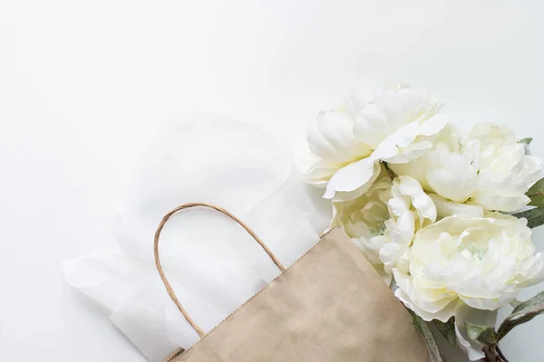 Paper bag with flowers on the white background