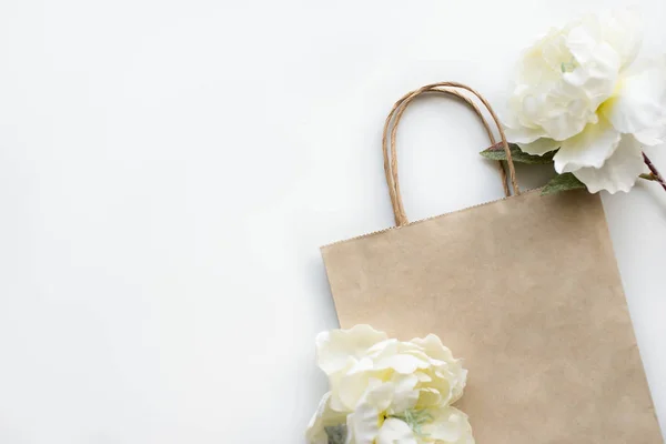 Paper bag with flowers on the white background