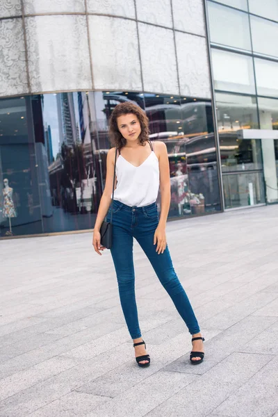Güzel kız modern bina yanında ayakta
