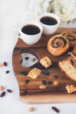 İki fincan kahve ahşap masa üzerinde tatlı ekmek ile