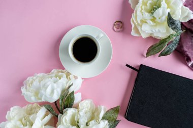 Şakayık çiçekleri Not ve kahve ile pembe arka plan üzerinde. Liste yapmak için planlama. Düz yatıyordu. Kadın çalışma alanı.