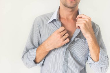 Genç bir adam onun elele Gömleğinin yakasında closeup. Beyaz bir arka plan üzerinde izole