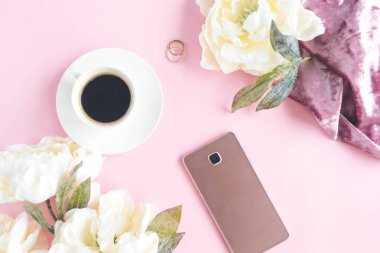Fincan kahve ve pembe arka plan şakayık ile telefonda
