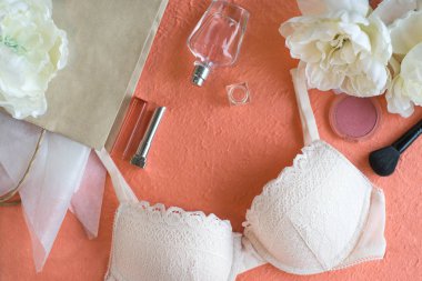 Hafif pembe sutyen ve makyaj ürünleri pic renk arka plan üzerinde.