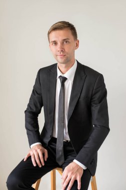 Gri arka plan üzerinde izole iş adamı, yakışıklı bir portresi oturan