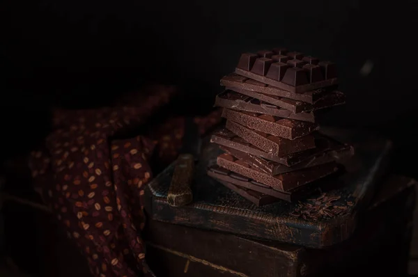 Una pila di blocchi di cioccolato, foto scura — Foto Stock