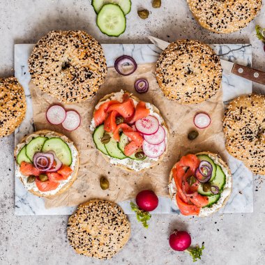 Krem peynirli bagel sandviçi, somon balığı ve sebze, kare.