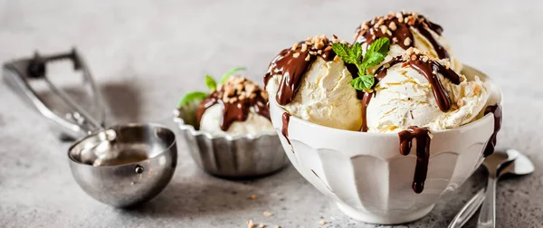 香草冰淇淋勺与巧克力软糖和切碎的坚果顶部 — 图库照片