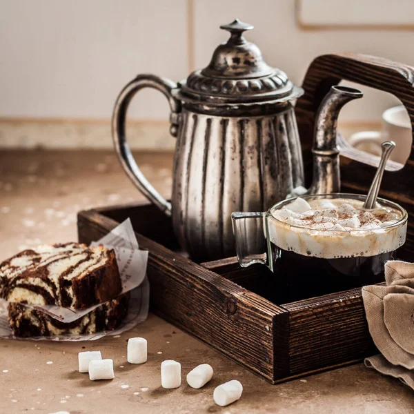 Coffee with Marshmallows and Slices of Zebra Cake on a Kitchen Table in a Wooden Tray, square