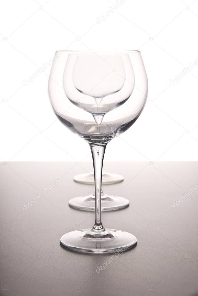 clear clean transparent wine glasses in a row on a white background