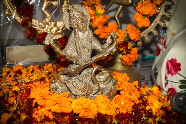 Goddess Saraswati figure. Hindu puja. Incense, offerings, petals, marigold flowers. Traditional, indian, altar, religion, holiday, Navratri, still life. — Stock Photo, Image