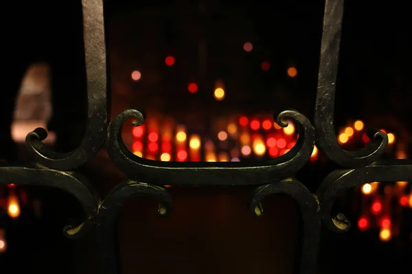 Brandende kaarsen in de kapel achter het antieke smeedijzeren hek. Allerheiligen, All Hallows Eve, Kerstmis, kerk, godsdienst, gothic, crypt. — Stockfoto