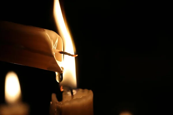 Iluminando uma vela no escuro, gotas de cera derretida, chama. Fecha. Natal, Ano Novo cartão de saudação, fundo, igreja, religião, fé, oração, feriado, conto de fadas de inverno, Halloween . — Fotografia de Stock