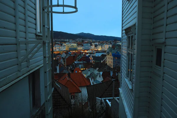 Vista de Bergen, Noruega al atardecer. Casas de madera tradicionales, techos de azulejos, faroles, paisaje urbano, fiordo, montañas. Monumento histórico de Noruega . — Foto de Stock
