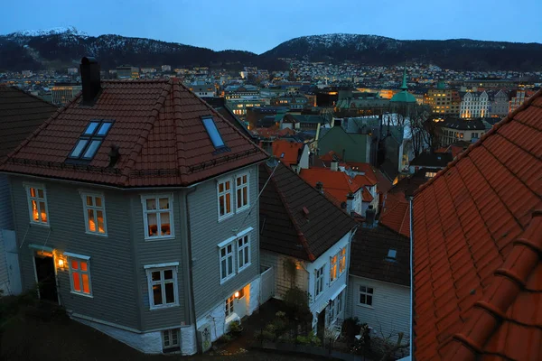 Bergen paisaje urbano al atardecer. Edificios históricos, luces de ciudad, montañas. Monumento histórico de Noruega . — Foto de Stock