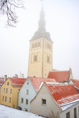 Aziz Nikolaos veya Niguliste kilise kırmızı arasında ünlü görünümünü rooftops Tallinn eski şehirde bir sisli kış gününde döşenir. Estonya dönüm noktası. Kış masal.