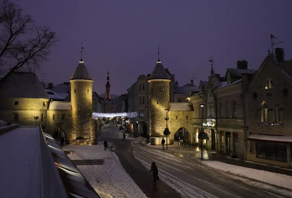 Tallin, Estonia - 7 de enero de 2019: vista de las puertas del casco antiguo con torres de castillo y un Ayuntamiento en la madrugada de invierno. Europa atracción turística . — Foto de Stock