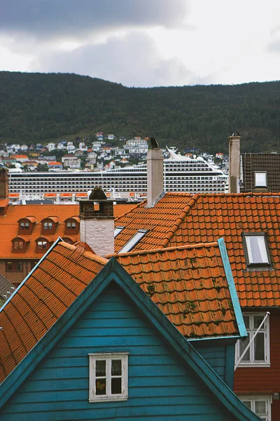 Картопляні дахи в старому місті Берген. Гори, хмари, дерев'яні будинки, димарі, круїзний корабель. Гордаланд (Норвегія). — стокове фото