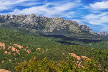 Kırım dağlarının manzarası, bulutlu gökyüzü ve vadi. Chatyr-Dag dağlık kitlesi, Kırım. Ünlü yürüyüş rotası..