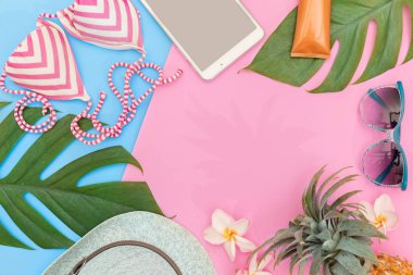 Tropikal üstten görünüm yaz tatil kavramı natürmort monstera liana, asma, palmiye yaprakları, güneş gözlüğü, krem ve pembe bir arka plan düz üzerinde hasır şapka yerleştirme düzeni