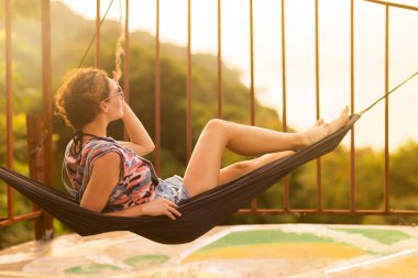 Tropikal egzotik hamak günbatımı ışıklar genç ince kadın