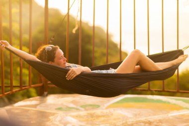 Tropikal egzotik hamak günbatımı ışıklar genç ince kadın