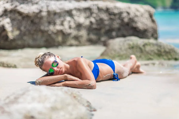 Junge hübsche blonde Frau im blauen Bikini am weißen tropischen Strand — Stockfoto