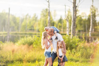 İki çocuklu mutlu sarışın Beyaz aile: erkek ve kız yaz Park