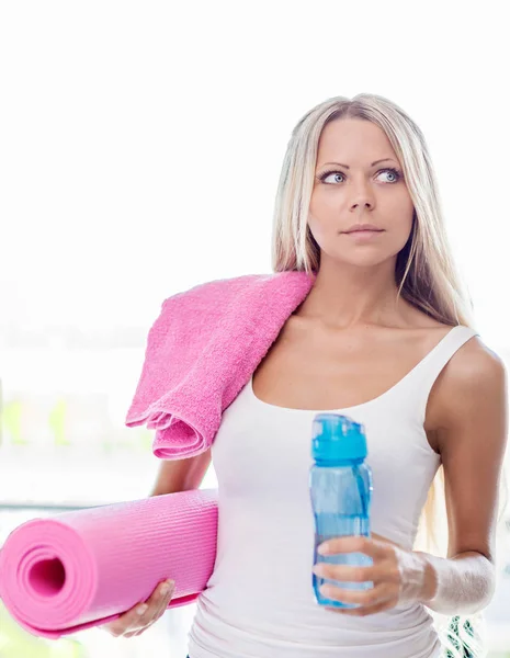 年轻的金发女人去健身运动与毛巾 瓶装水和粉红色瑜伽垫 — 图库照片