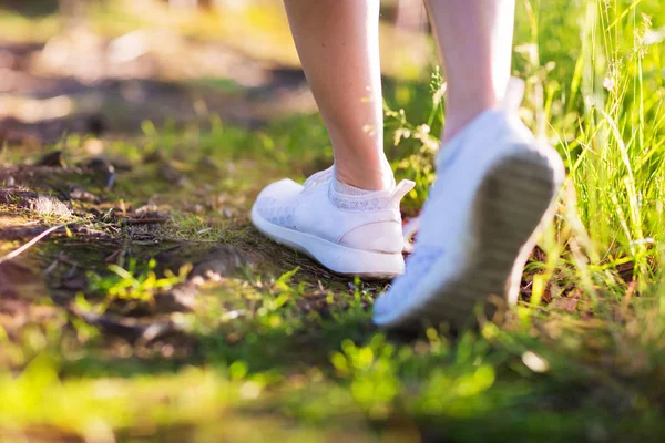 Jovem mulher correr na floresta de verão em luzes do pôr do sol — Fotografia de Stock