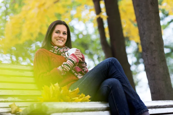 秋の公園でお茶を一杯の若い笑顔の女性 — ストック写真