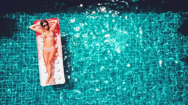 スイミング プールでピンクの空気マットレスの上はかなりスリムな女性 — ストック写真