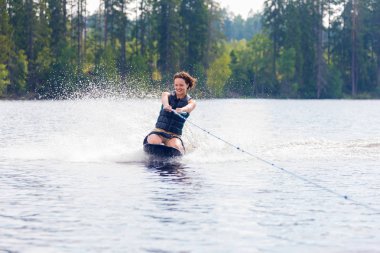 Genç atletik kadın kneeboard bir gölde sürme