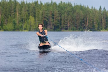 Genç atletik kadın kneeboard bir gölde sürme