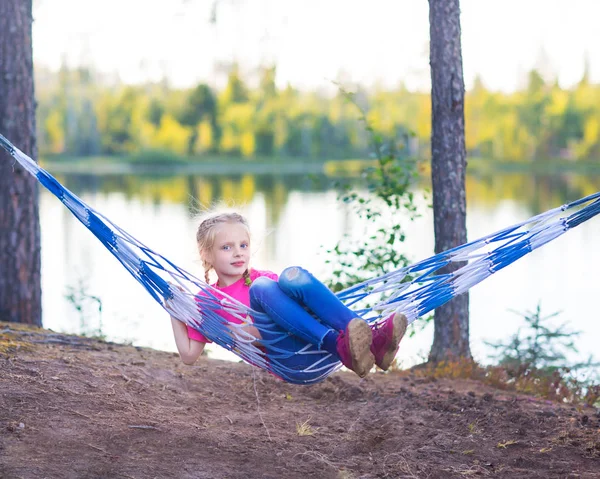 湖の近くのハンモックで小さな女の子子供 — ストック写真