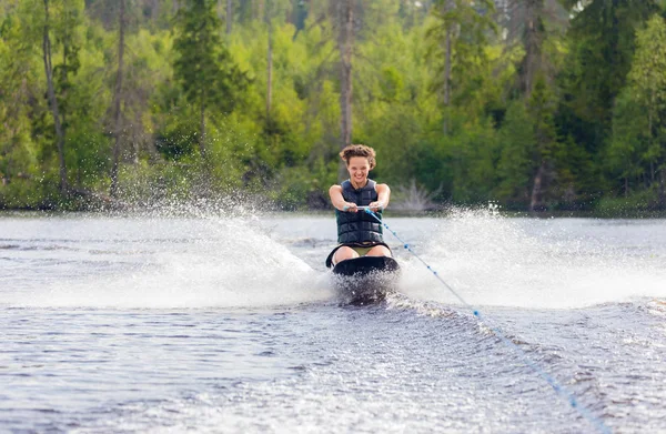 ニーボードを湖に乗って若い運動女性 — ストック写真