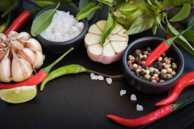 Baharatlar ve otlar siyah arduvaz arka plan üzerine yemek pişirmek için farklı