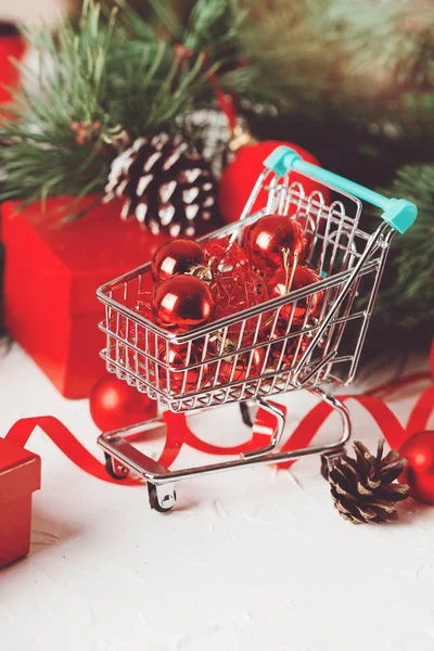 Red Christmas bauble in market basket with branch