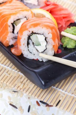 Ahşap bir arka plan üzerinde taze somon suşi rulo
