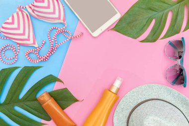 Tropikal üstten görünüm yaz tatil kavramı natürmort monstera liana, asma, palmiye yaprakları üzerinde pembe ve mavi renkli düz yerleştirme düzeni