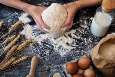 Karanlık bir arka plan üzerinde buğday ile hamur yoğurmak