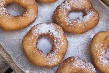 Ahşap bir zemin üzerine pudra şekeri krema ile ev yapımı çörek