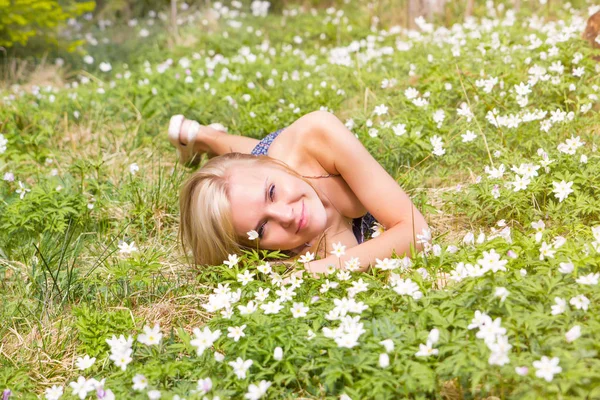 美丽的金发碧眼的女人在春天的草地上绽放白色的花朵 — 图库照片