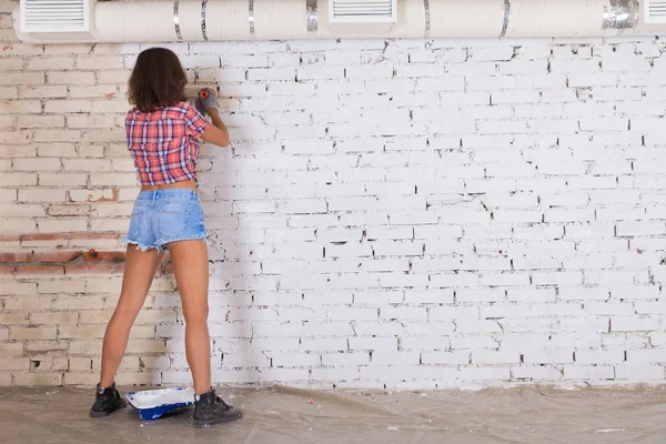 Молода Приваблива Жінка Малює Білою Цегляною Стіною Пензлем — стокове фото